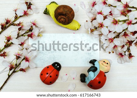 
snail and Lady-bugs posing on a blue background with cherry blossoms