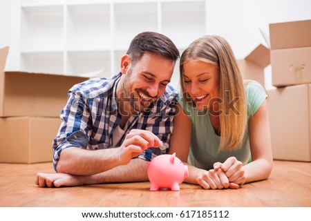 Young couple is saving money for their new home. Royalty-Free Stock Photo #617185112