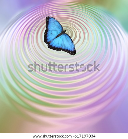 The Butterfly Effect - Big Blue Butterfly appearing to create ripples in pink green water surface with plenty of copy space below
