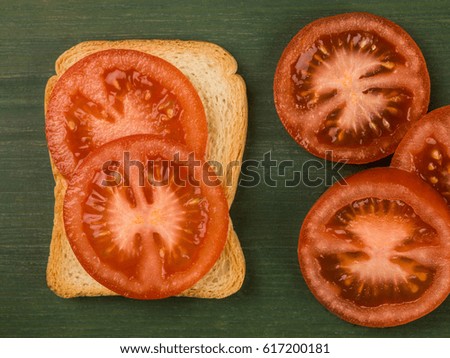 Sliced Tomato on French Toast Against a Green Background