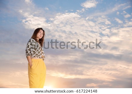 Young woman standing so sad on the mountein to sky background