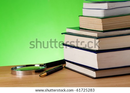 book, pen and magnifying glass on table