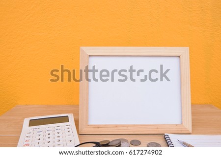Business on financial report . photo Frame and coin on a wooden on Yellow background . 