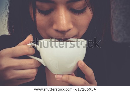 Asian young woman are drinking cup of coffee, vintage style. Royalty-Free Stock Photo #617285954