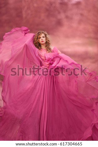 Beautiful girl in a pink dress in field