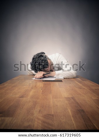 Crazy business man working on a wooden office table, wide angle shot with space for text or image
