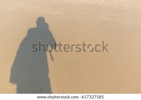 Shadow of people on beach sand at sunset time