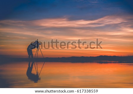 Silhouette Photographer take photo beautiful seascape at sunset in Thailand