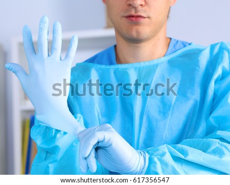 Young surgeon holding a scalpel. Ready for operation