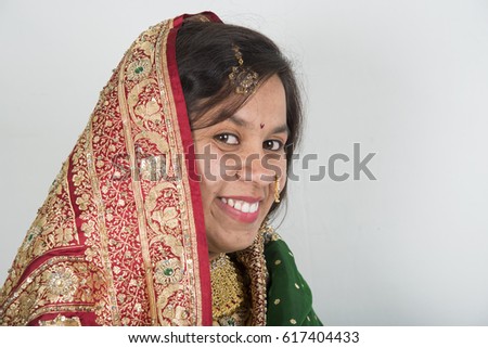 Cheerful indian young girl posing in traditional Indian saree on white background.