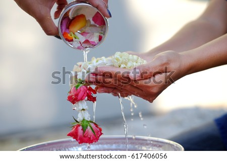 Hand of young woman pour water and flowers on the hands. older women and happy for the songkran festival. concept gives blessing in Songkran day Thailand Royalty-Free Stock Photo #617406056