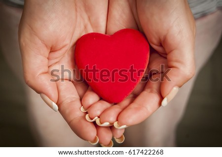 Young woman's hands holding a little red heart. Mother love concept illustration.
