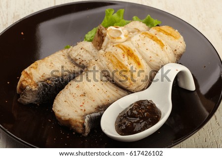 Grilled shark steak with pepper sauce and salad leaves