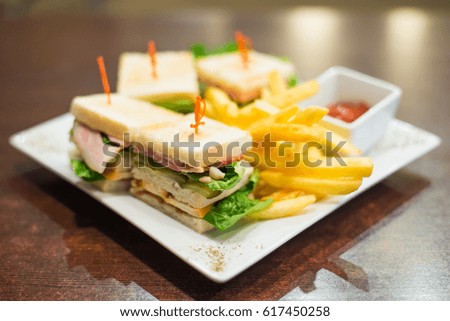 Mini sandwiches with fries and ketchup on a white plate closeup