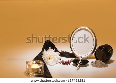 black urn with black tape, chrysanthemum,,candle, rosary for sympathy card on yellow background