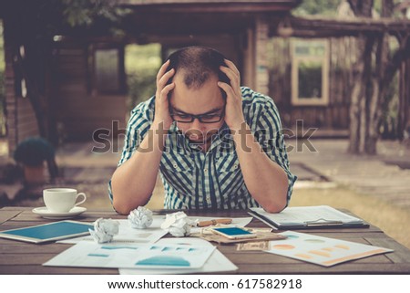 Side profile stressed young businessman sitting outside corporate office holding head with hands looking down. Negative human emotion facial expression feelings.  Royalty-Free Stock Photo #617582918