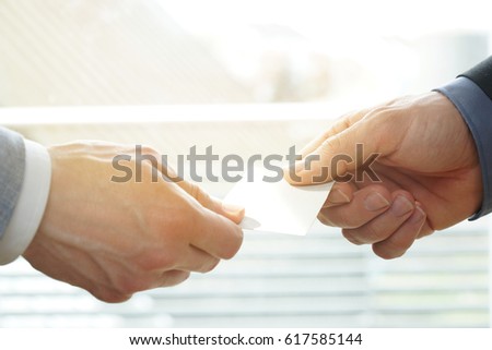 Businesspeople exchanging Visiting Card In Office with sunshine. You can use the blank visiting card as copyspace.