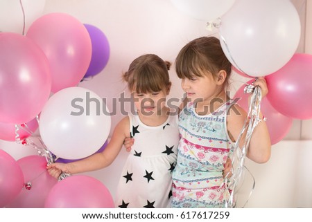 Sibling sister children in dresses playing with balloons, concept happy childhood and holiday,lifestyle