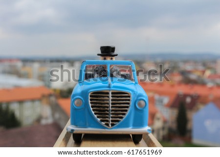 Blue car toy in wood rail with blured city in background