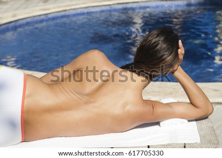Woman in swimsuit lying  at the edge of a swimming pool
 Royalty-Free Stock Photo #617705330