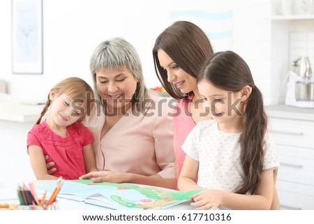 Family with book sitting at kitchen table
