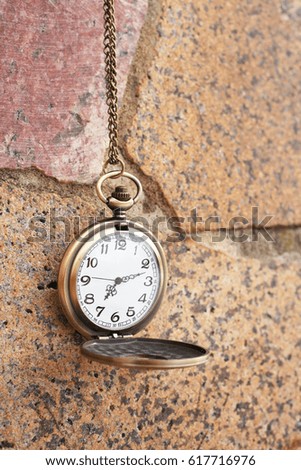 Vintage golden pocket watch on rock background, time concept.  