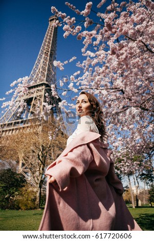 Beautiful girl on background of the Eiffel tower in bloom