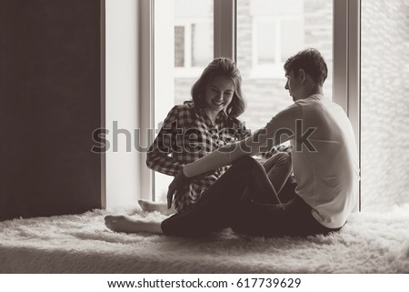 young couple in love get funny on the window, the black-and-white photo