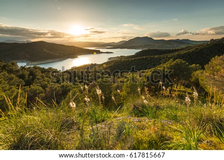 Sunset over lake in mountains from hill top