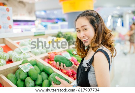 Asian woman shopping Unripe mango in a supermarket