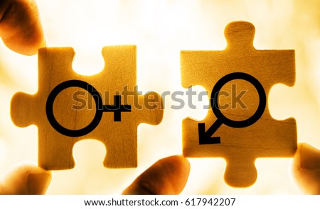 Couple In Love. Mars and Venus wooden symbols together. Hand holding wooden jigsaw puzzles. photo image, isolated on sunset sky background. Sword of Mars. Venus mirror
