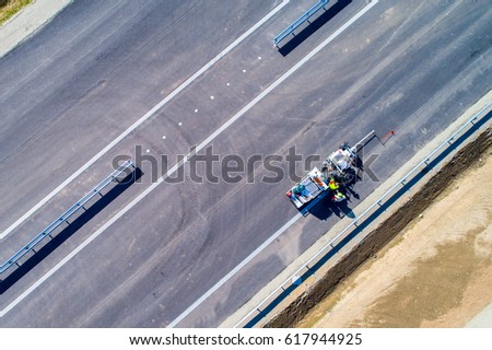 Aerial view on the workers painting the lines on the road