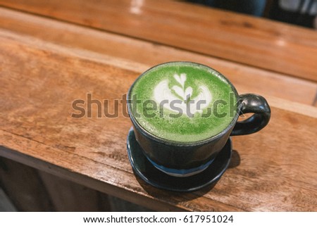 Hot macha latte green tea on a wood background 