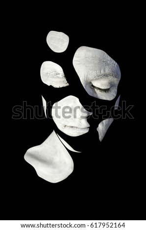 Emotional man with artistic white makeup. Creative greasepaint on male face, isolated on black background. 