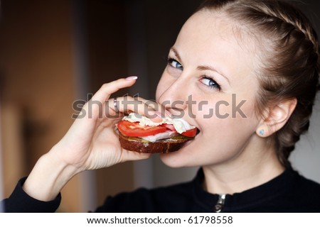 Beautiful young woman eating hamburger