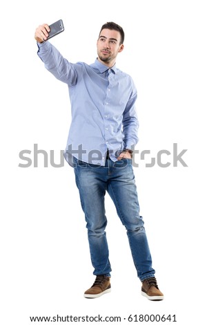 Happy successful businessman taking selfie looking at smart phone. Full body length portrait isolated over white background.