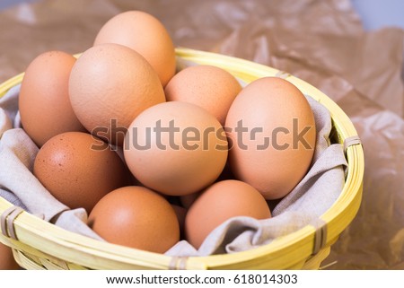 Country eggs in a basket on a gray background
