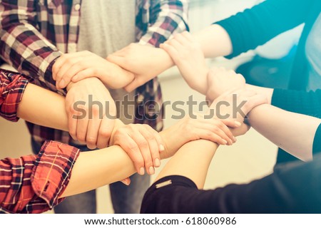 A group of young people hold strong hands. Sign of trust and teamwork. Royalty-Free Stock Photo #618060986
