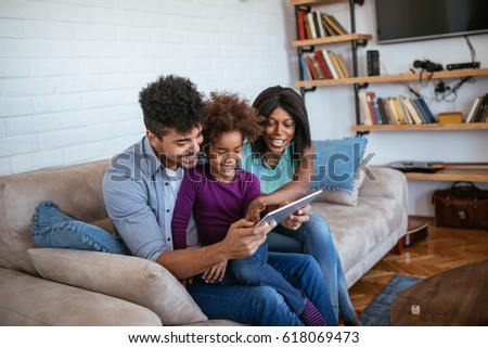 Happy african american family surfing the net on the tablet.