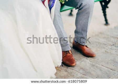 Brown shoes on male legs. Groom in gray trousers.