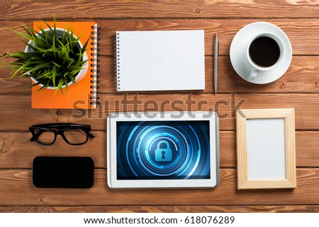 Business workplace with office stuff and tablet with padlock icons on screen