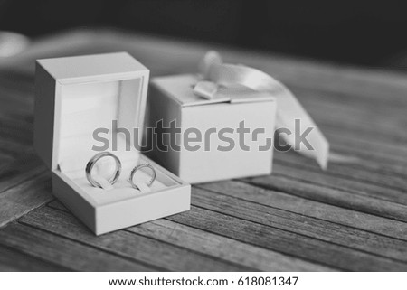 Wedding rings on a light wooden texture in a blue box. Wedding jewelry. Black and white photography.