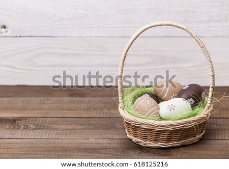 Happy easter! Beautiful Easter eggs are decorated in bed colors in a basket on a wooden background. Easter conceptual background.