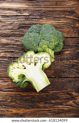 Inflorescence of raw broccoli on a wooden table, vertical photo