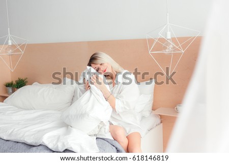 Portrait of beautiful young woman holding a pillow and slepping on bed
