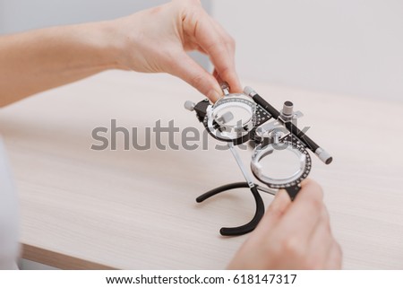Nice professional doctor holding eye test spectacles