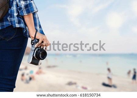 Women holding camera and sea background, concept trave in summer