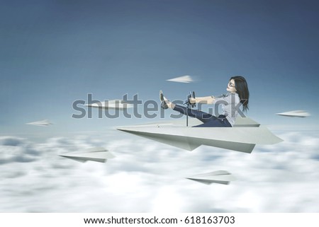 Picture of a young businesswoman drives a paper plane on the sky