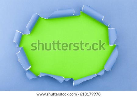 Blue ripped open paper on green paper background