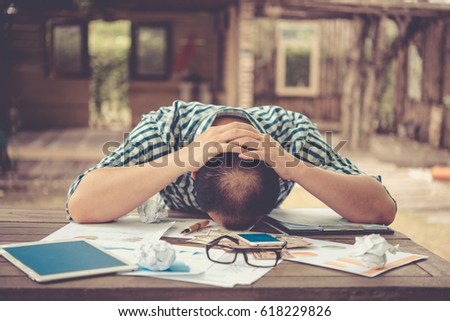 Young businessman lying face down on the desk., Business Failure concept Royalty-Free Stock Photo #618229826